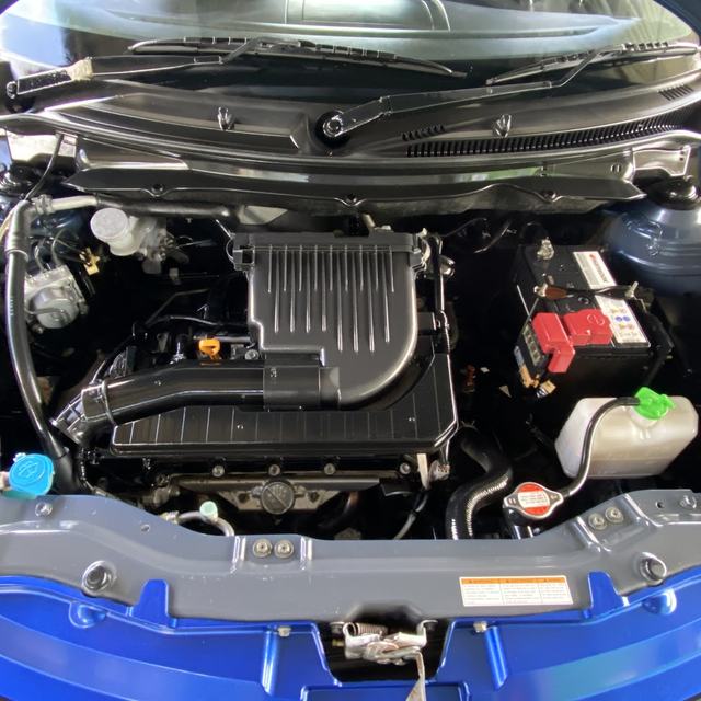 Engine bay of a blue car during a service